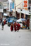 Monks walking down a town street