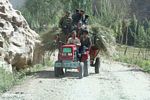 Group of Tajik men riding a tractor