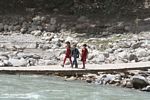 Tajik kids crossing a river by bridge