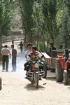 Boy and his father riding a motorcycle riding down the main street in Datong village
