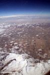 Airplane view of snow-capped mountains and desert in western China