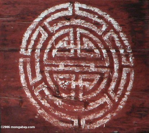 Muster gemalt auf einem roten Stall in tibetanischem Yunnan