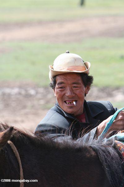 Tibetanischer Cowboy, der ein Pferd tibetanisches