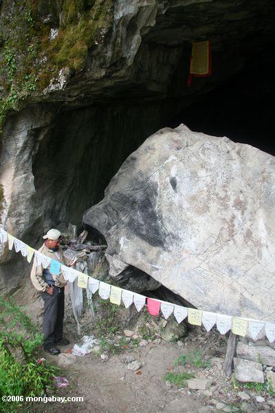 вход в пещеру вдоль Янцзы, буддийские молитвы флаги на переднем плане