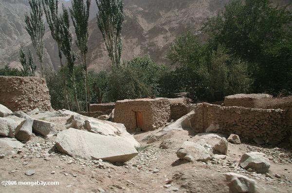 Parede e casas da lama em uma vila de Tajik