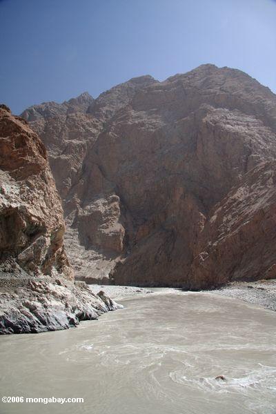 Rio e montanhas glacial enlameados em Xinjiang ocidental remoto