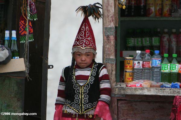 Junges chinesisches Mädchen, das auf einem Stand nahe einem Paßprüfpunkt auf der Karakoram Landstraße Xinjiang