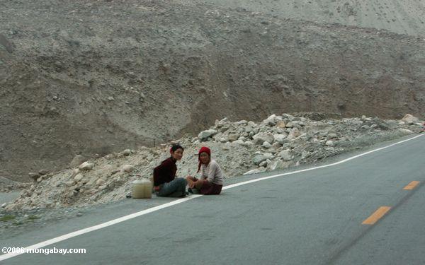 две девочки сидели вдоль шоссе Каракорум