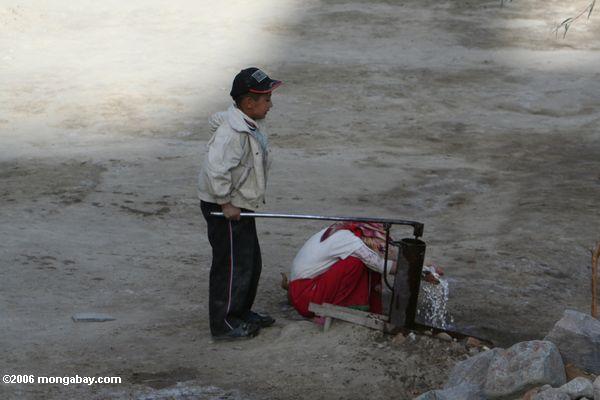 Мальчик откачки воды, как его мать моет, tashkurgan