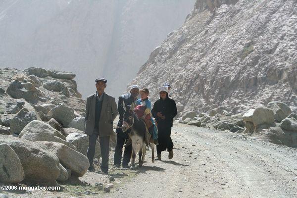 таджикская семья пешком вдоль пыльной дороге