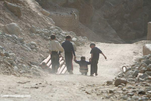 Дети играли в пыли, грязи Датун в дороге