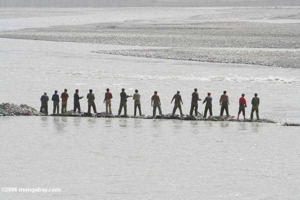 Männer, die einen Fluß in Remotechina Xinjiang