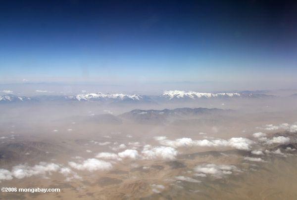 雪をかぶった山々の新疆で空中を表示