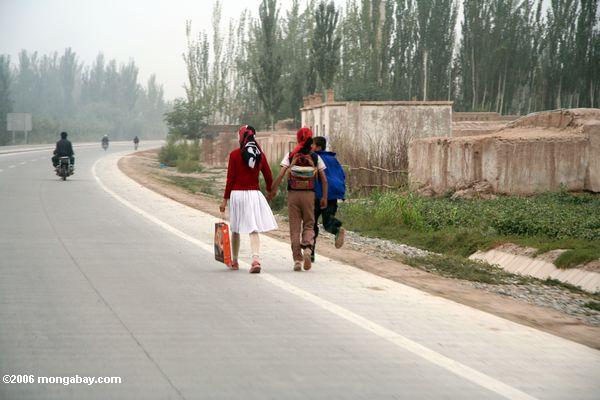 カシュガルウイグル人の子供たちの近くの道路に沿って作業
