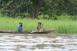 Girls paddling a dugout canoe in the Amazon
