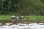 Group of local girls paddling a dugout canoe in the Amazon
