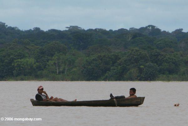 Zwei Jungen, die in einem Dugout auf dem Amazonas Fluß Leticia-Amazonas