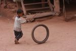 Boy pushing a tire with a stick