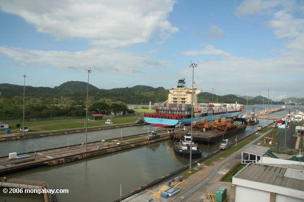 Navio de recipiente que passa através do fechamento de Miraflores do canal de Panamá